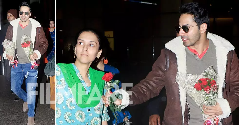 Varun Dhawan distributes roses to his fans at the Mumbai airport